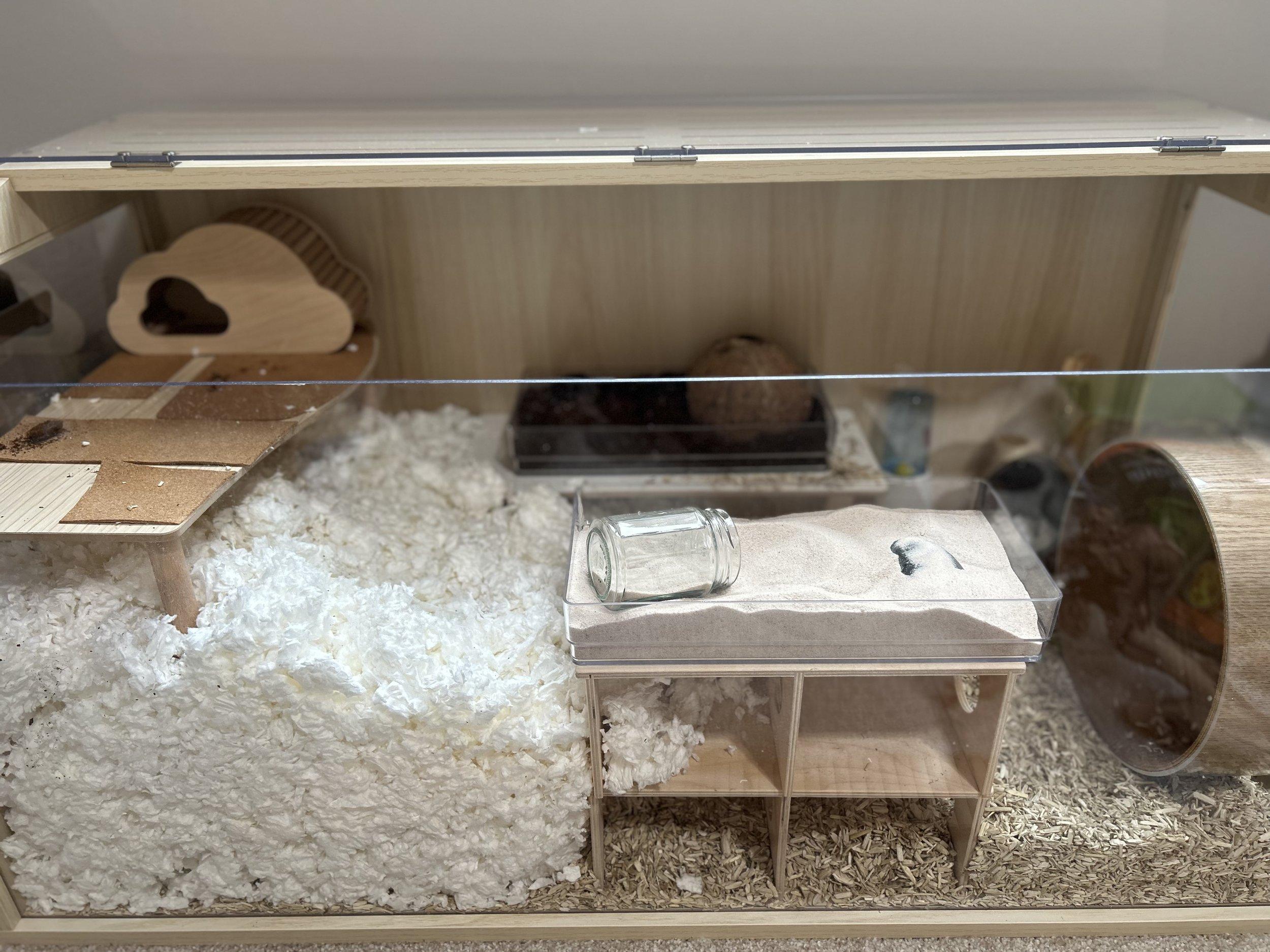  A hamster cage with a variety of bedding materials